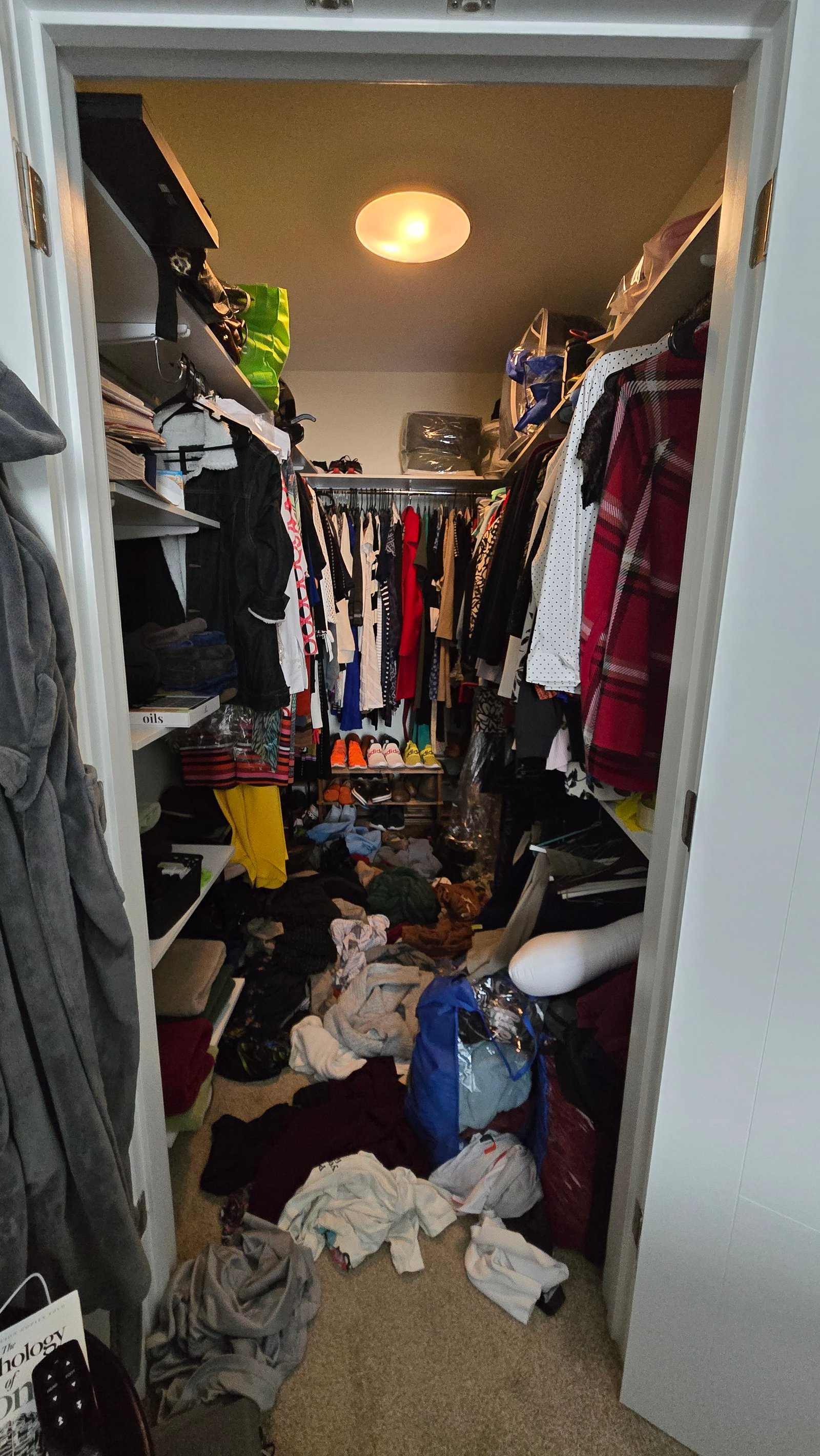 Walk-in closet before — clothes on floor, no system
